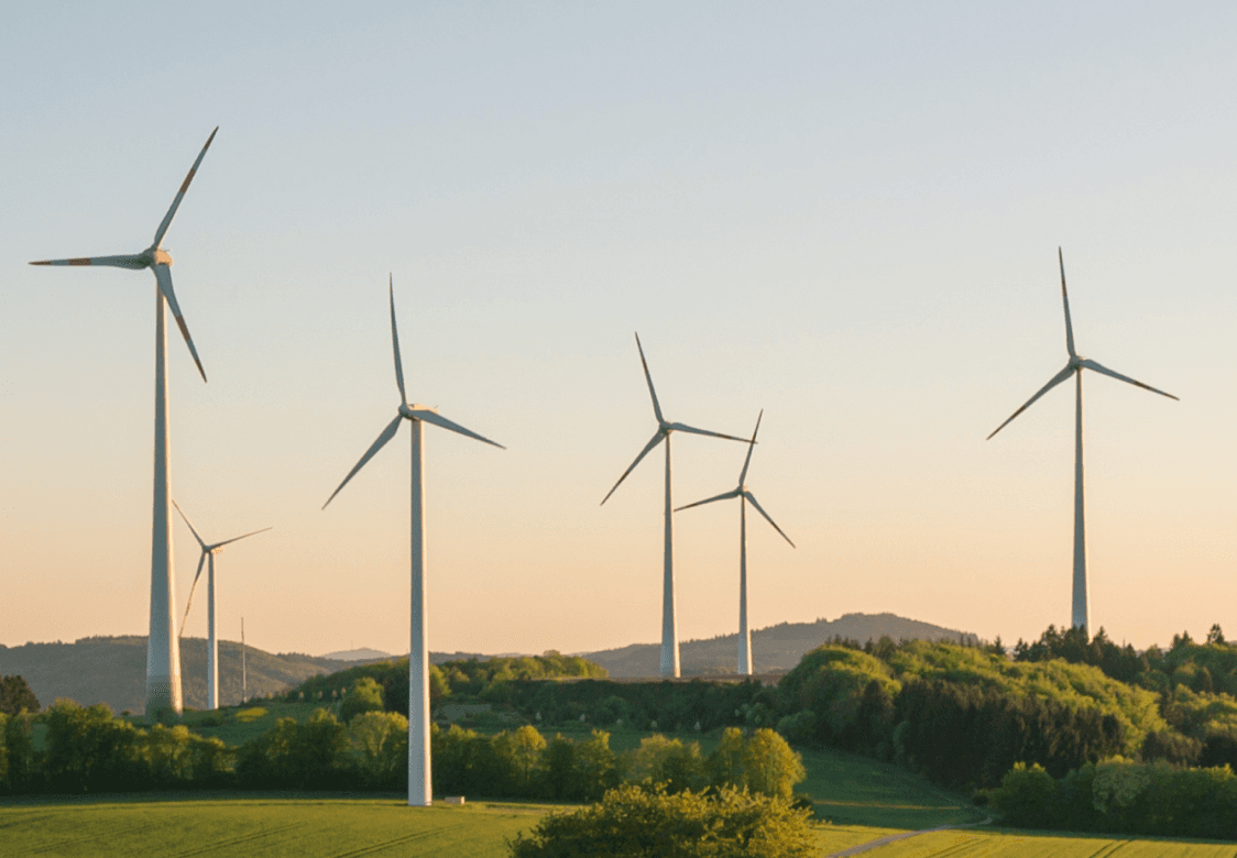 Windmills on a field at dusk